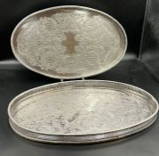 Two white metal trays with pierced sides with decorated trays.