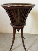 An Edwardian jardiniere or plant stand with brass liner and caps to feet