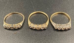 A selection of three diamond rings, all with five stones in yellow gold settings.