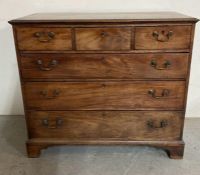A three over three oak chest of drawers with drop handles (H97cm W111cm D55cm)