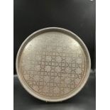 An Arabian silver tray on three feet, inscribed to back.
