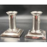 A pair of squat silver candlesticks, hallmarked for London 1881, makers mark JB probably James
