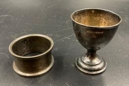 A hallmarked silver egg cup and a napkin ring