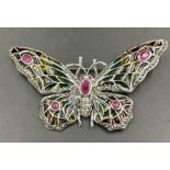 A silver and applique enamel butterfly brooch set with a ruby.