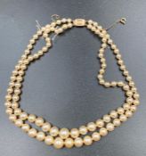A double string pearl necklace with a 9ct gold clasp.