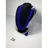Three strand blue beaded necklace with chorded adjustable tassel, approx. 645cts each bead