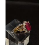 18ct yellow gold Ruby and diamond cluster ring, set with central oval ruby of approximately 4ct,