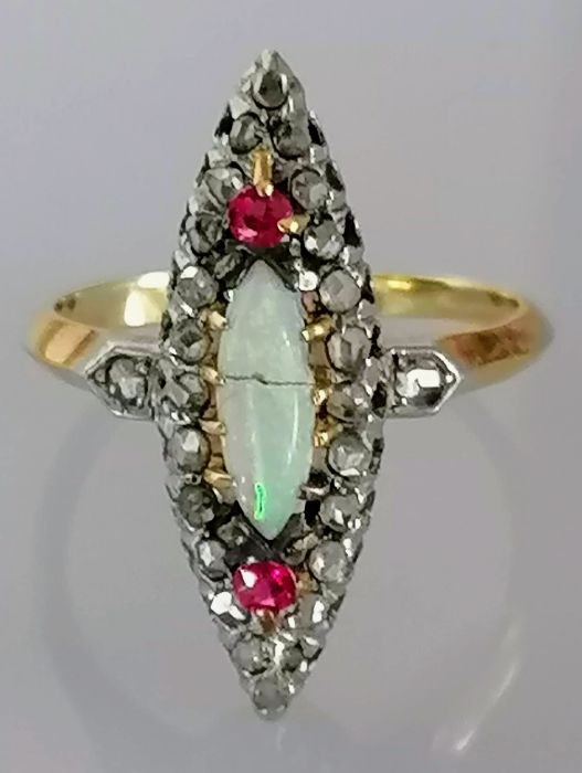 An Edwardian opal, ruby and diamond ring in a yellow metal cage setting, size O