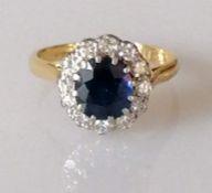 A sapphire and diamond cluster ring on an 18ct yellow gold setting, the sapphire 8 x 7mm surrounded