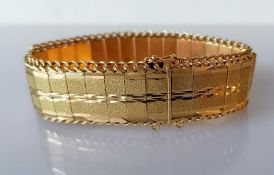 A vintage gold articulated bracelet with textured links and curb-link chain edge, 19 cm, test for 14