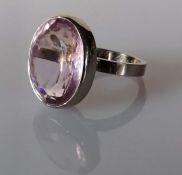 An oval-cut pale pink paste stone, 19 x 16 x 8mm, weighing an estimated 17.00 carats, bezel-set, mou