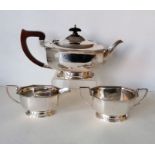 An Art Deco silver three-piece tea service of faceted design with gadronned edges on raised bases, t