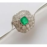 An Art Deco emerald and diamond platinum brooch, the emerald 5mm x 6mm, thirty-one round-cut diamond