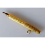 A yellow gold pencil holder with fluted decoration, unmarked, tests for 18ct gold, 68mm, 12g