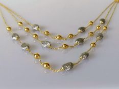 An Italian yellow gold three-strand bib necklace with white textured beads, 46 cm, Cyprus assay mark