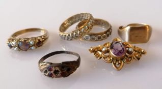 An assortment of four gold gem-set rings, a signet ring and a amethyst and seed pearl brooch, all ha