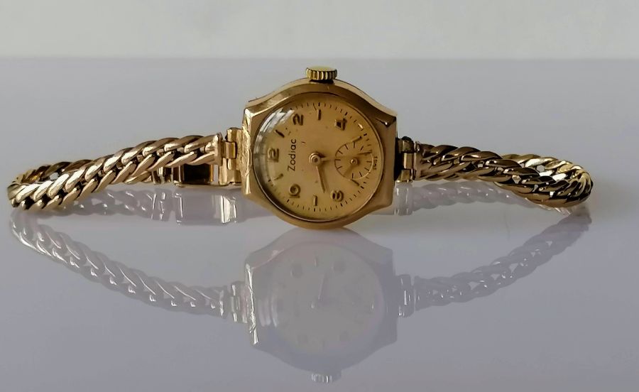 A gold-cased ladies 9ct gold Zodiac dress watch with subsidiary seconds hand on a woven gold strap,