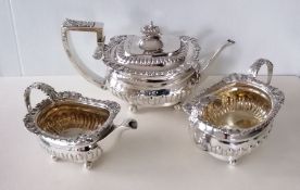 A Victorian silver three-piece tea service with acanthus leaf and shell scroll decoration on ball fe