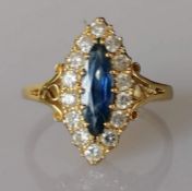 An 18ct yellow gold marquise-set sapphire and diamond ring, sapphire 13 x 5mm, the fourteen round-cu