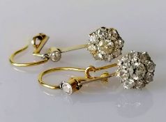 A pair of white and yellow metal diamond earrings, the central round-cut diamond approximately 0.20