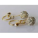 A pair of white and yellow metal diamond earrings, the central round-cut diamond approximately 0.20