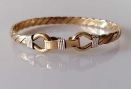 A gold bangle of woven design with clasp, unmarked but tests for 9ct, 37.8g