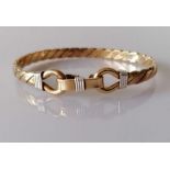 A gold bangle of woven design with clasp, unmarked but tests for 9ct, 37.8g