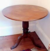 A George IV mahogany circular flip-top table with fluted support on a tripod base, 69 H x 75 cm diam