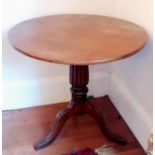 A George IV mahogany circular flip-top table with fluted support on a tripod base, 69 H x 75 cm diam