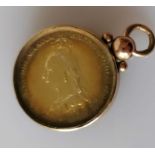 A Victorian Jubilee Head Shilling, 1887, cased in a 9ct gold pendant, 11.02g