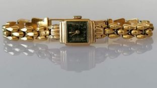 A vintage ladies gold dress watch with black face and Arabic numerals, Swiss mechanism on an 18ct go