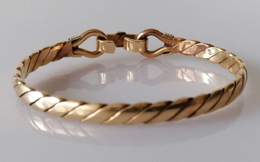 A gold bangle of woven design with clasp, unmarked but tests for 9ct, 37.8g - Bild 2 aus 2