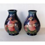A pair of Moorcroft 'Finches' pattern vases tubelined with the birds against a dark blue ground, imp