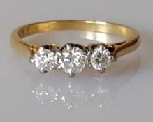 An 18ct yellow gold three-stone diamond ring, central round-cut diamond 0.02 carats, size M, 2.54g