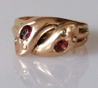 An Edwardian rose gold crossover snake ring decorated with round-cut garnets, size T, hallmarked twi
