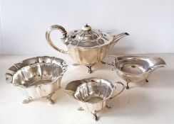 An Edwardian three-piece silver tea service with faceted decoration, each on four hoof feet by Atkin