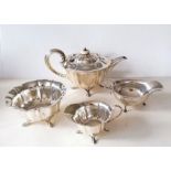 An Edwardian three-piece silver tea service with faceted decoration, each on four hoof feet by Atkin
