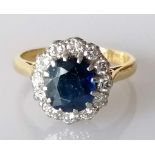 A sapphire and diamond cluster ring on an 18ct yellow gold setting, the sapphire 8 x 7mm