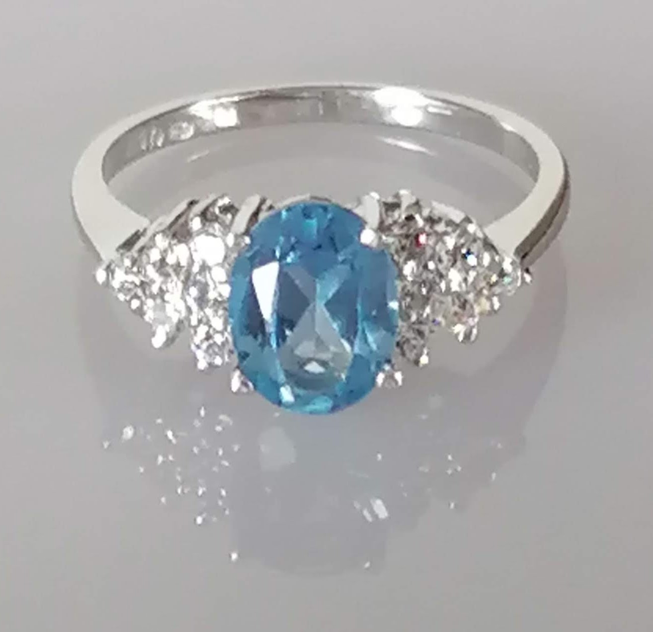An oval blue topaz, 7 x 5mm, on white gold ring with cubic zirconia decoration to shoulders, size L, - Image 2 of 6