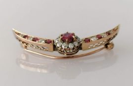 A garnet and diamond crescent-shape rose gold brooch, the central garnet approximately 0.50