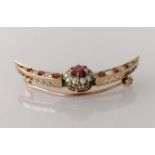 A garnet and diamond crescent-shape rose gold brooch, the central garnet approximately 0.50