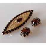 A mid-century Italian elliptical gold and garnet brooch, 66mm x 19mm and matching clip earrings,