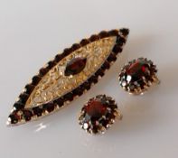 A mid-century Italian elliptical gold and garnet brooch, 66mm x 19mm and matching clip earrings,