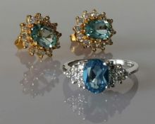 An oval blue topaz, 7 x 5mm, on white gold ring with cubic zirconia decoration to shoulders, size L,