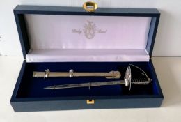 A miniature ceremonial sword/letter opener by Pooley, London, with metal scabbard and fitted case,