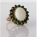 An opal and emerald cluster ring on a 9ct yellow gold setting, the opal 20mm x 12mm, showing pink