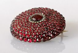 A Victorian circular convex garnet and seed pearl brooch on a base metal back, 35mm