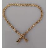 A 9ct yellow gold fancy-link necklace with integrated bow pendant and ruby decoration, hallmarked,