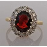 An oval garnet cluster gold ring surrounded by fourteen round-cut diamonds, each 0.02 carats