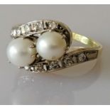 An Art Deco-style pearl and diamond crossover ring on white and yellow gold